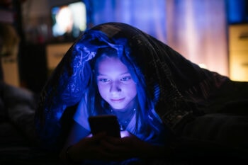 Child on phone in bed