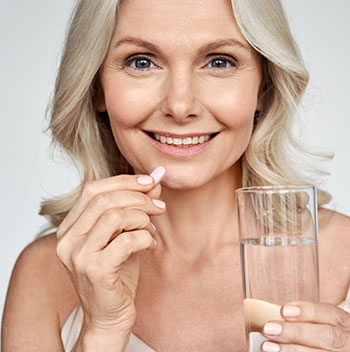 Older woman taking vitamin pill