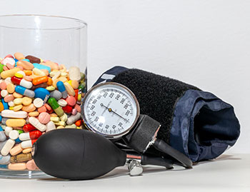 Blood pressure cuff beside jar of medication