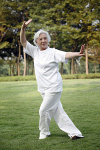 Older woman doing tai chi in the park