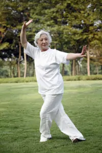 Older woman doing tai chi in the park