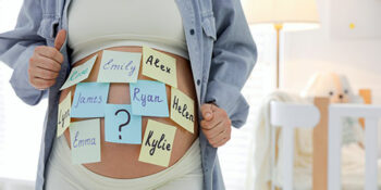 Pregnant woman with baby name sticky notes on stomach