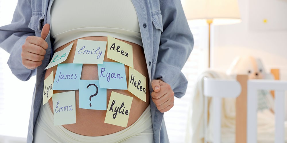 Pregnant woman with baby name sticky notes on stomach