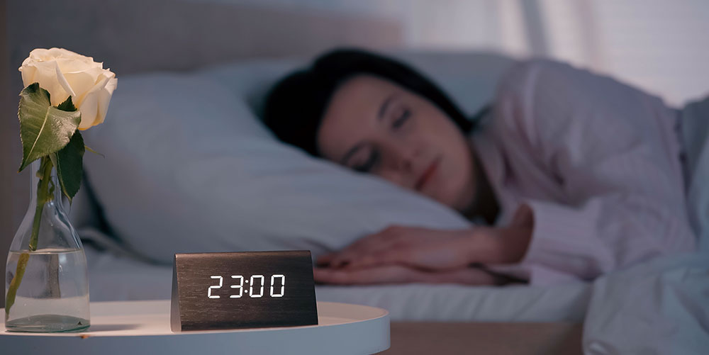 Woman asleep, clock reads 2300