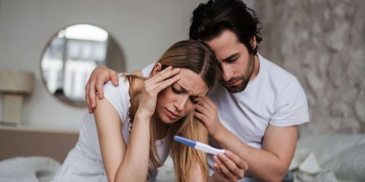 Sad couple looking at pregnancy test