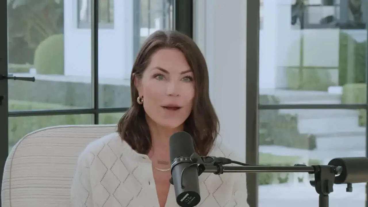 Dr. Thais Aliabadi speaking into a microphone in a modern clinic setting.