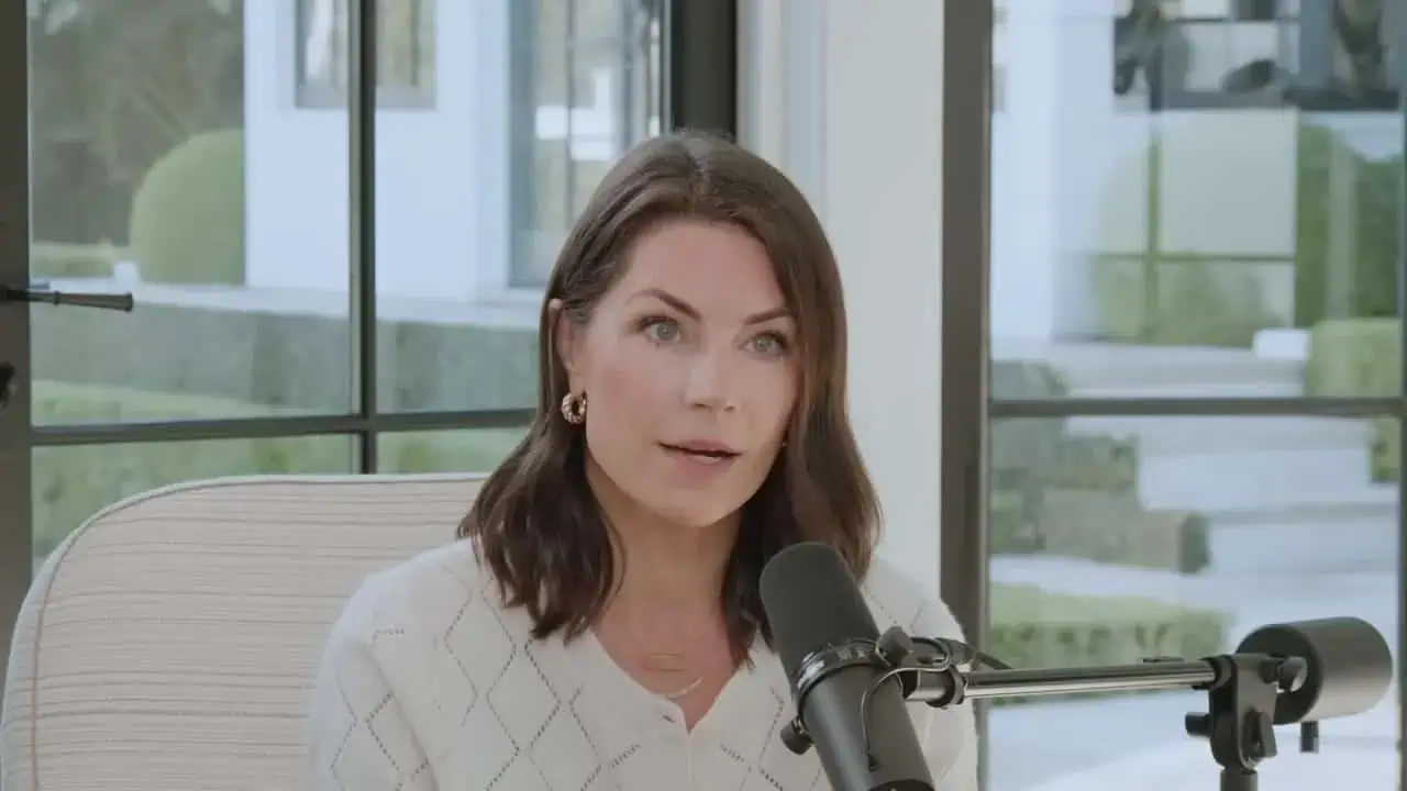 Dr. Thais Aliabadi, MD speaking into microphone in a professional setting.