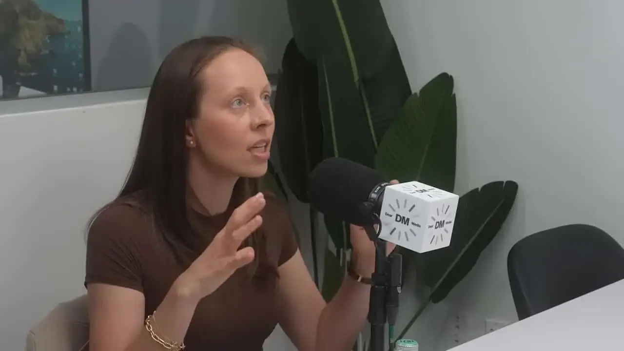Dr. Thais Aliabadi speaking into a microphone during an interview or presentation.