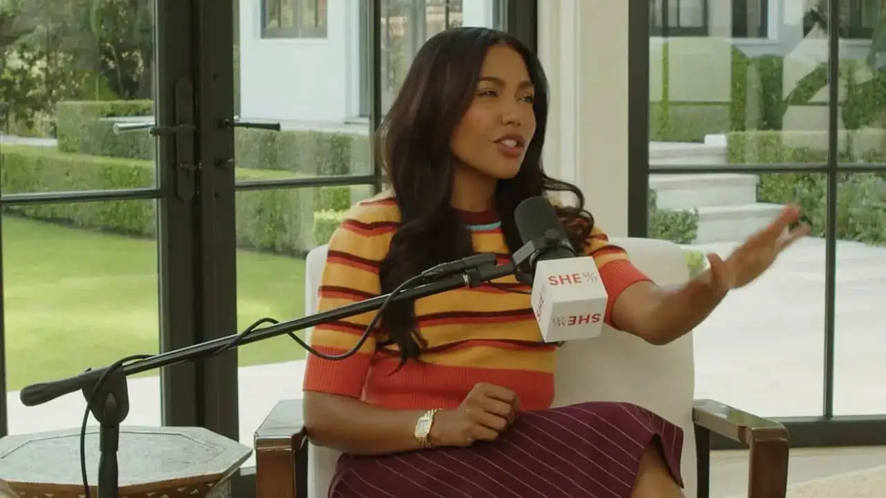 Emma Grede speaking confidently during a podcast interview with studio lighting and microphone