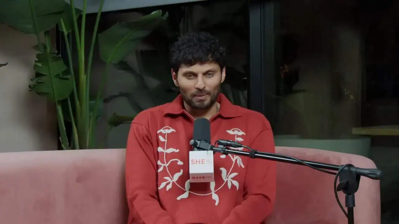 Dr. Thais Aliabadi speaking at a public event with microphone.