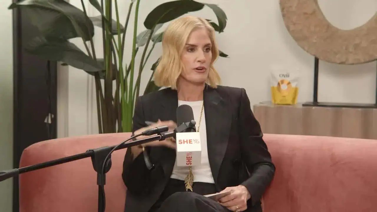 Thais Aliabadi MD speaking into a microphone during a press event. Focus on her professional appeara.