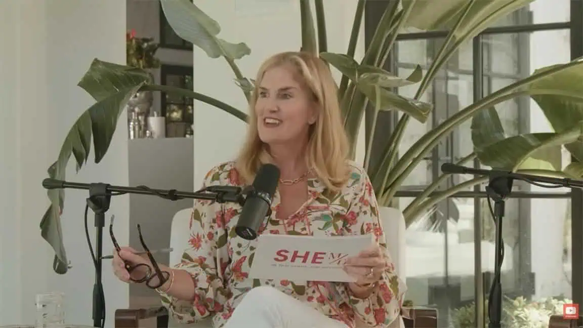 Thais Aliabadi MD delivering a speech at a professional event with a microphone.