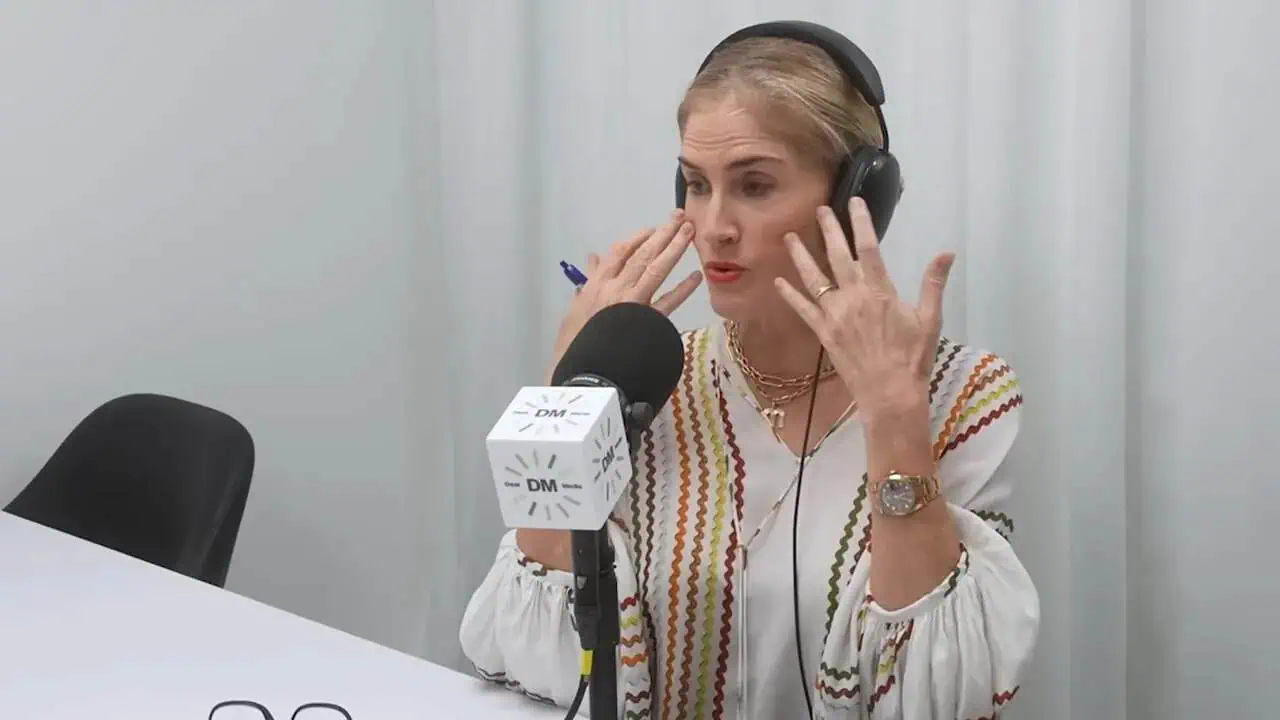 Dr. Thais Aliabadi recording podcast with headphones and microphone.