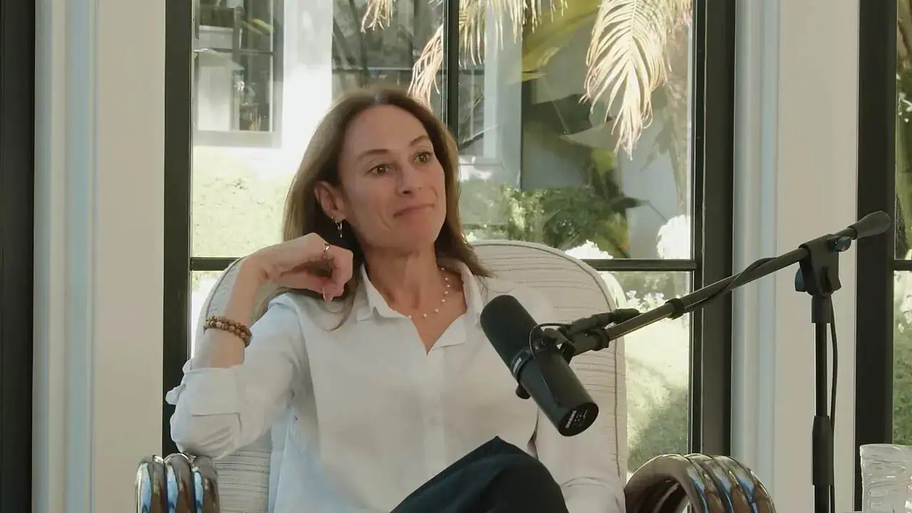 Thais Aliabadi MD speaking at a podcast or interview in a modern office environment.