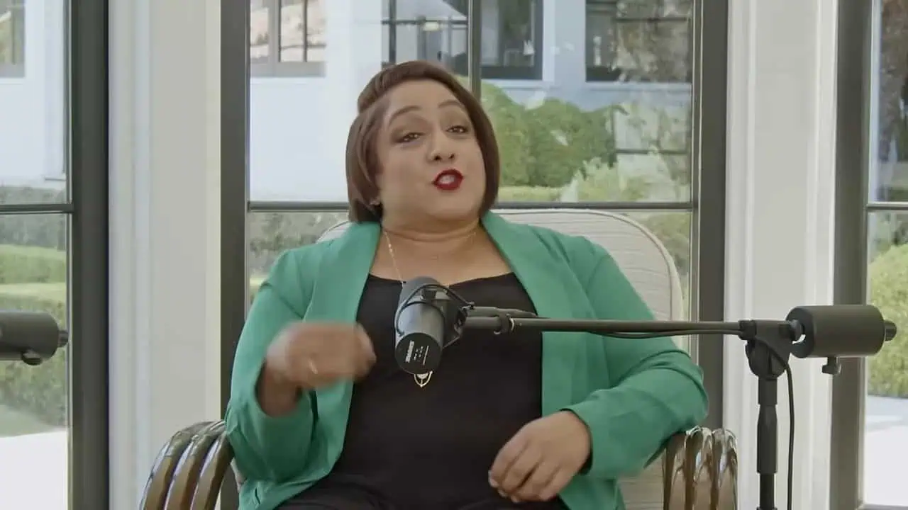Thais Aliabadi MD speaking in a professional setting with a microphone.