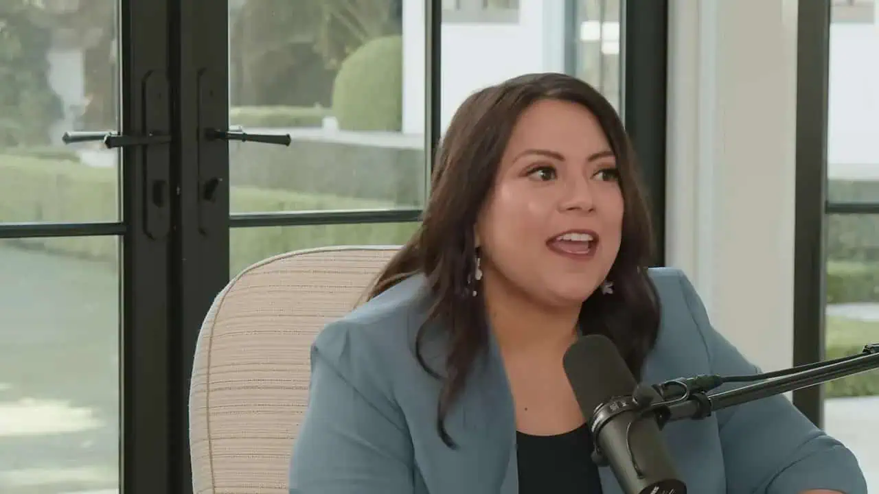 Thais Aliabadi MD speaking into a microphone in a professional setting.