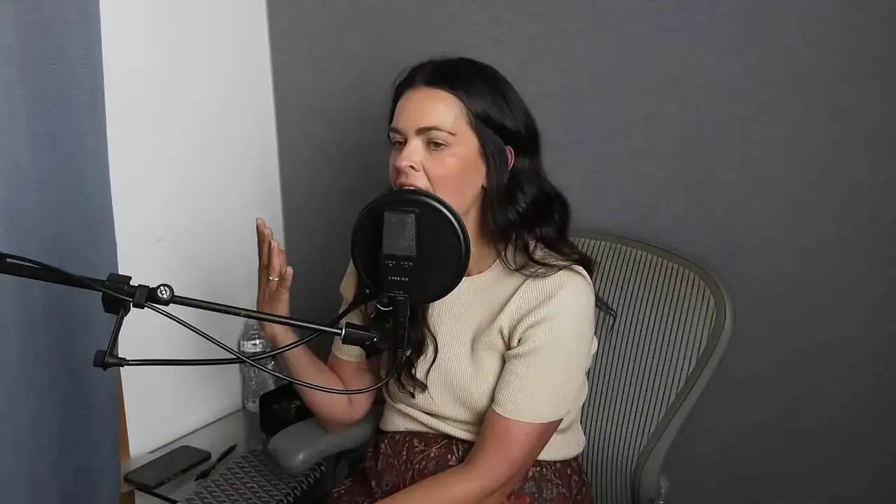 Thais Aliabadi MD speaking into microphone during podcast recording.