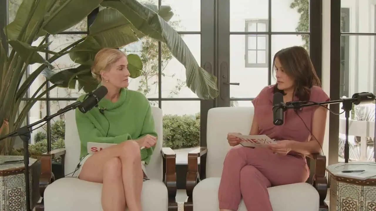 Two women seated in armchairs discussing menopause symptoms in a bright studio