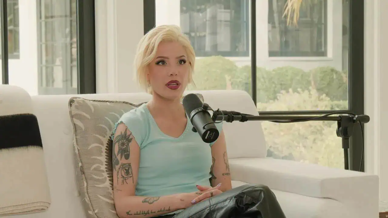 Halsey seated in a white chair speaking into a microphone