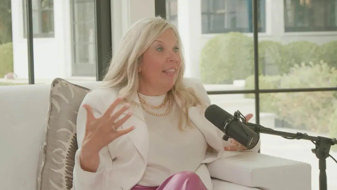 Heather Salazar speaking into a microphone in a white chair