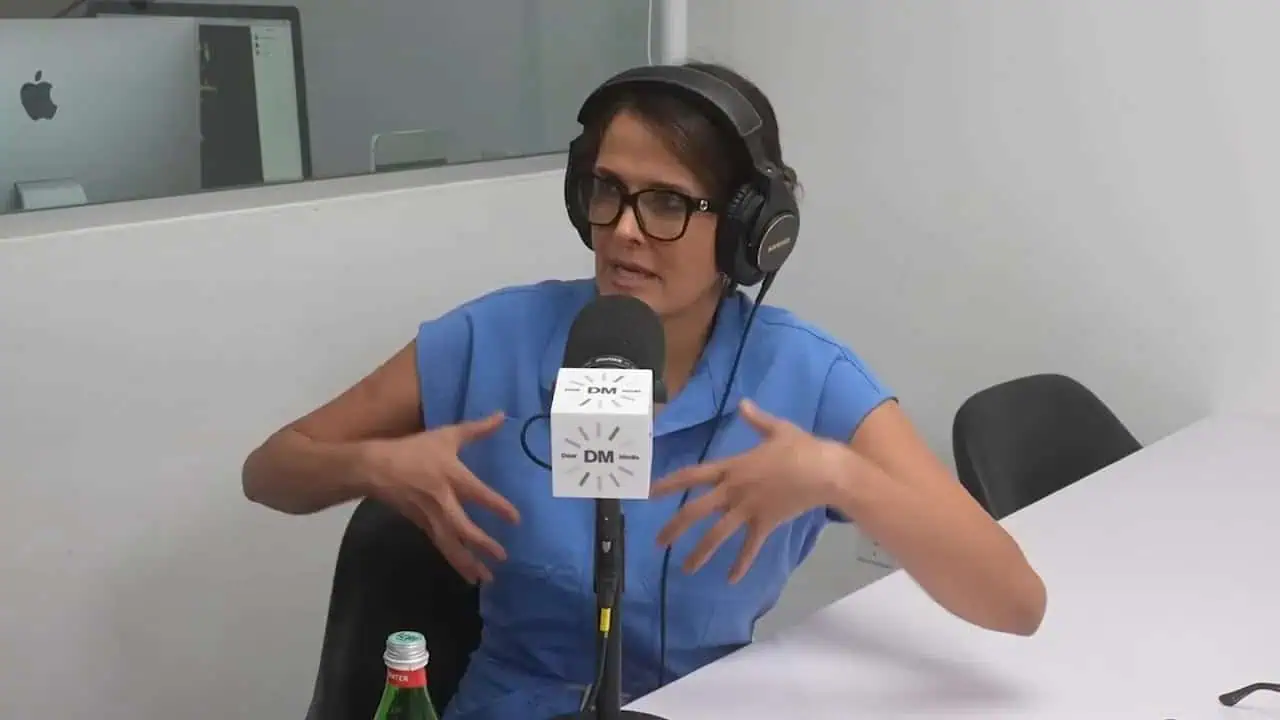 Dr. Thais Aliabadi speaking into microphone during podcast interview.