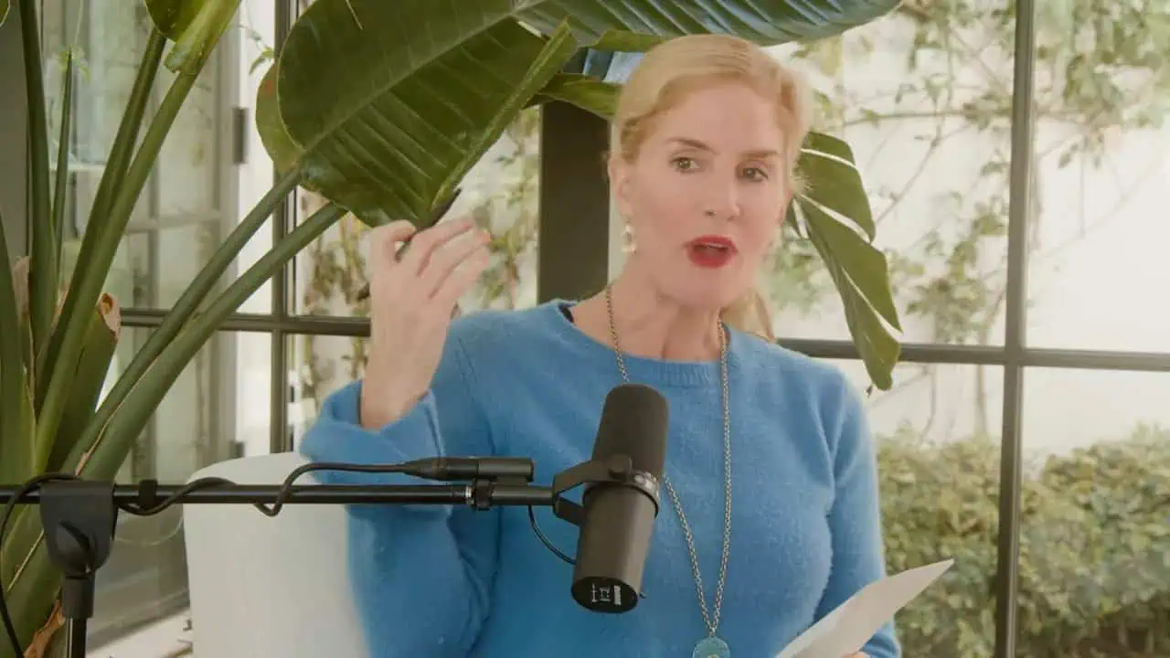Dr. Thais Aliabadi speaking, wearing a blue top, with a microphone in front.