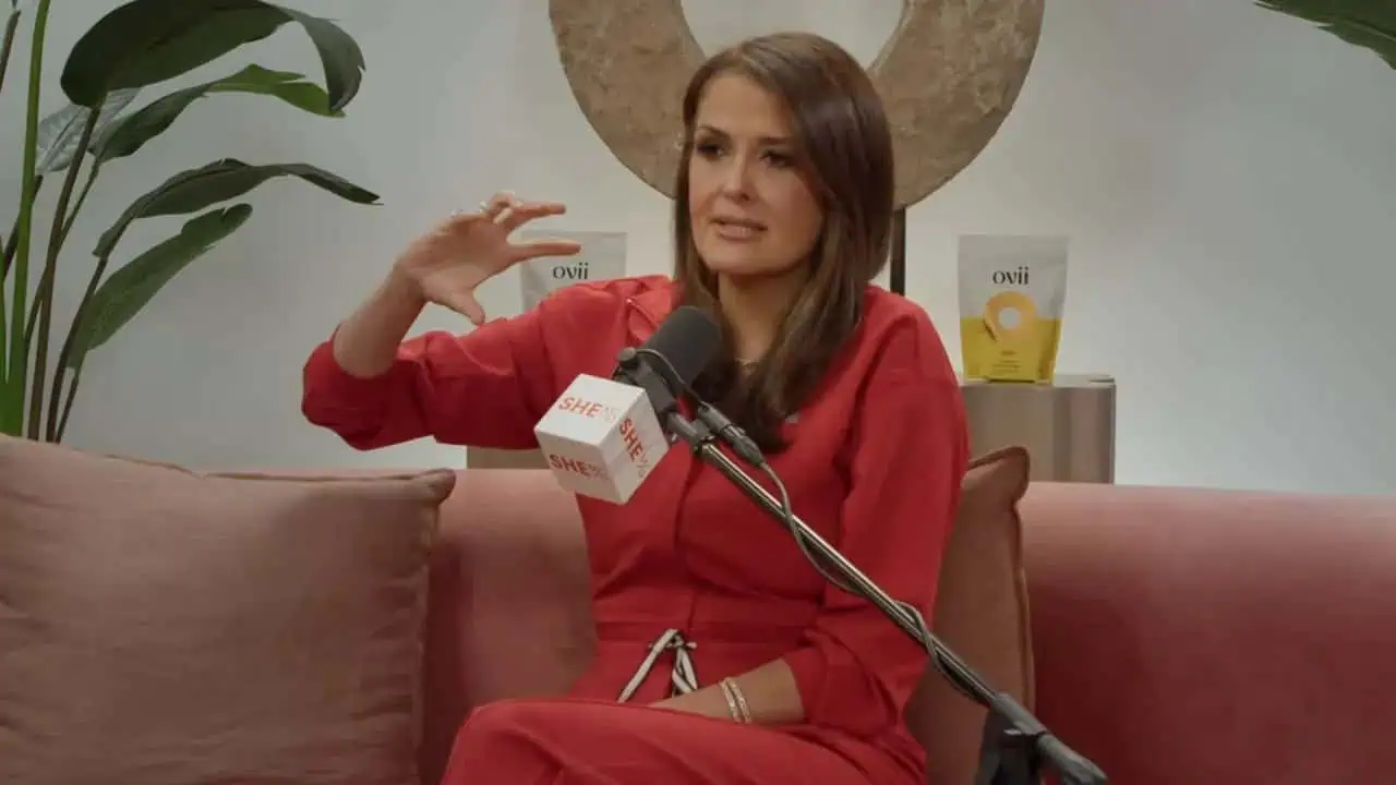 Thais Aliabadi MD speaking at a podcast interview in a red outfit.