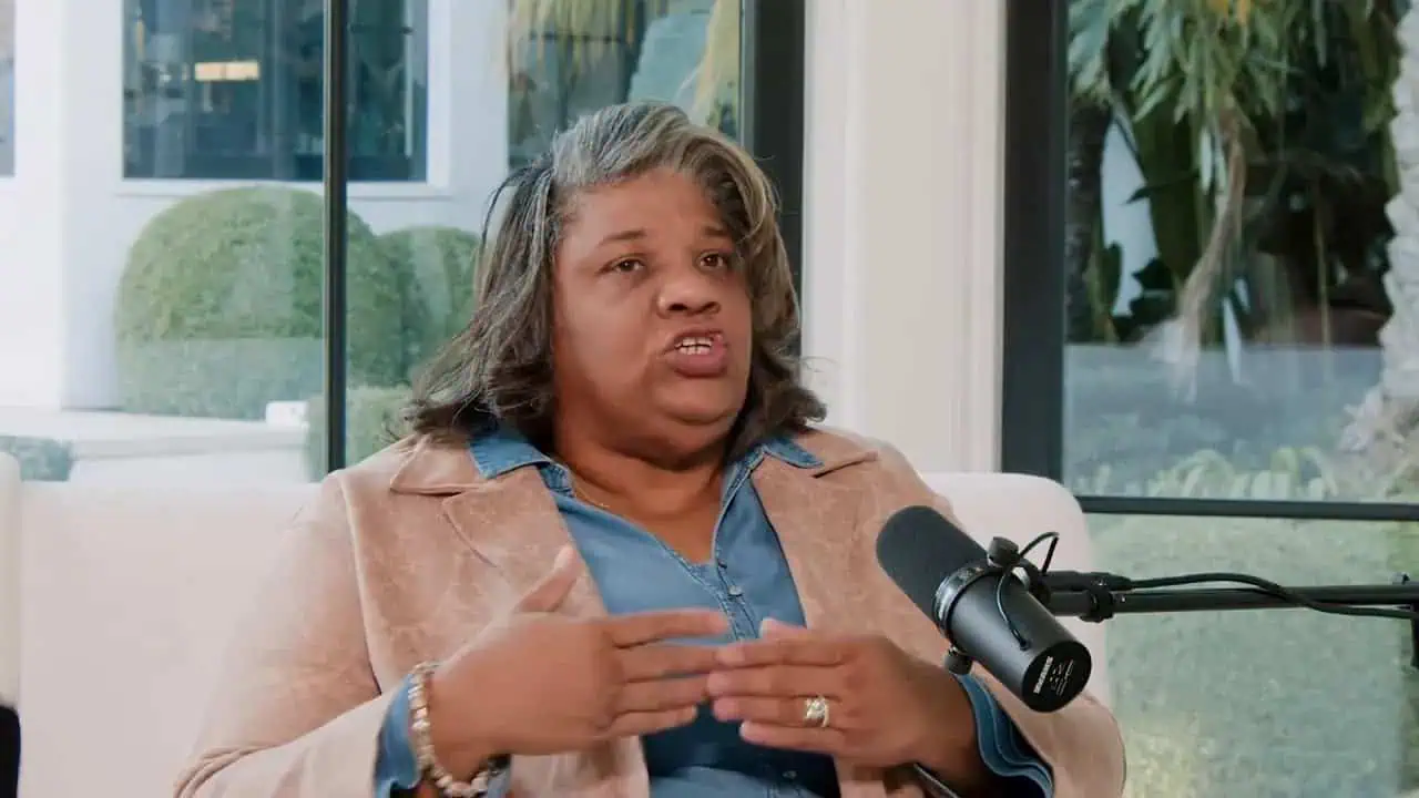 Dr. Thais Aliabadi speaking into a microphone during an interview or presentation.