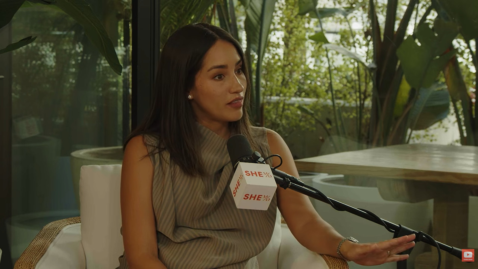 Dr. Thais Aliabadi speaking into a microphone during an interview.
