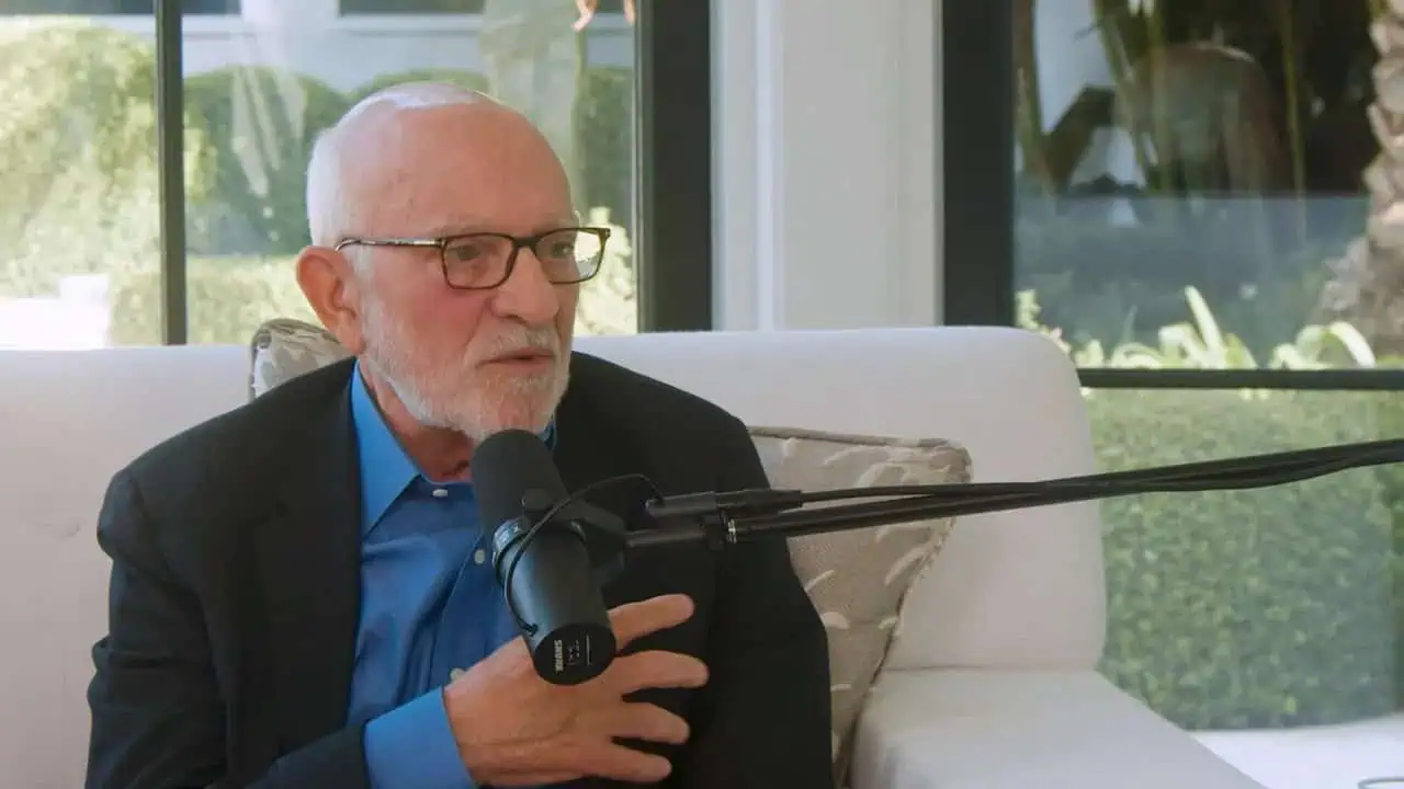 Dr. Ali Abadi speaking into microphone in a bright, modern setting.