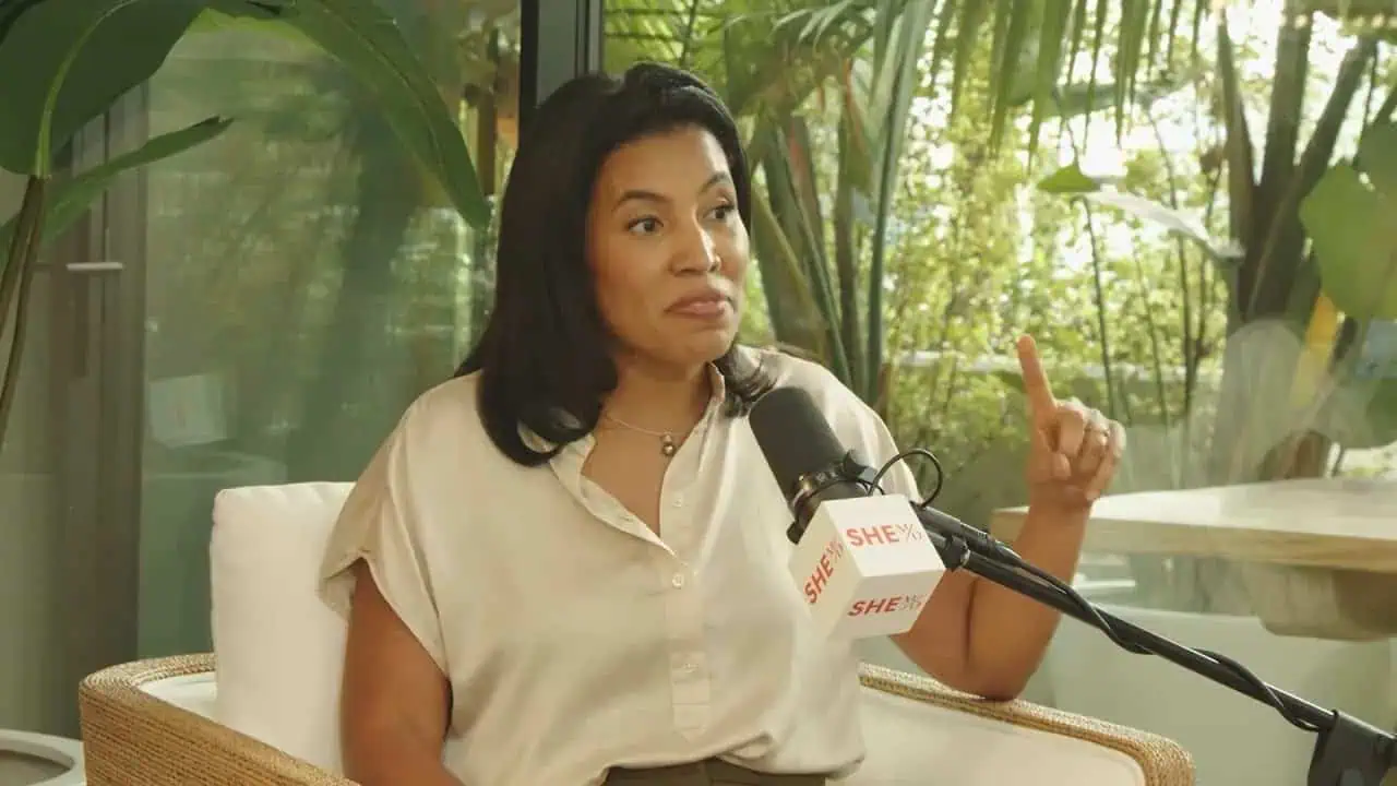 Dr. Heather Woolery-Lloyd holding her hands apart while speaking into a microphone