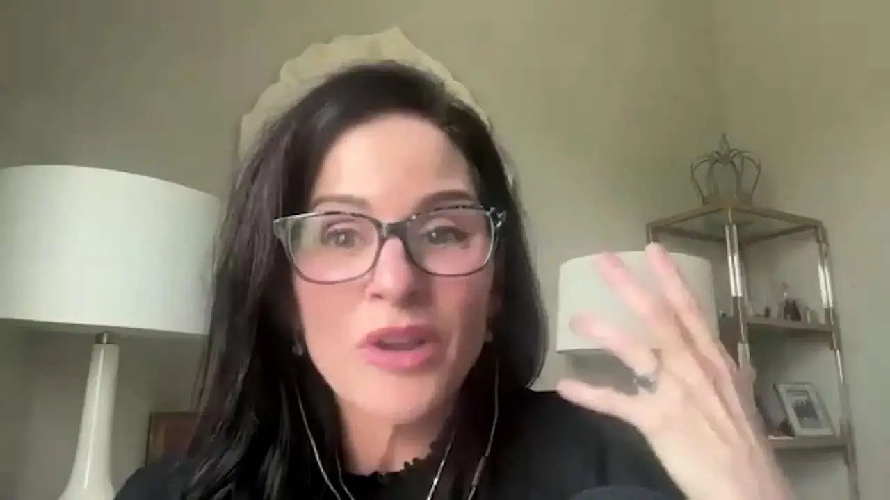 Thais Aliabadi MD speaking, wearing glasses, in a professional setting.