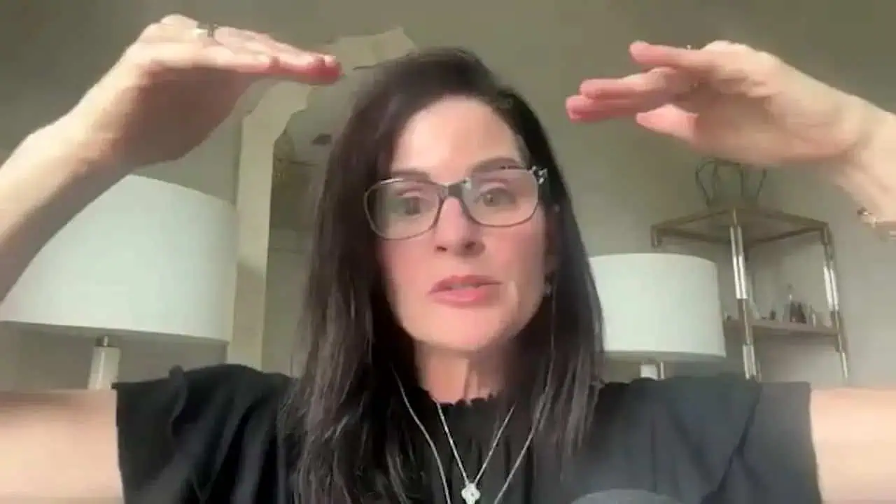 Thais Aliabadi MD in a professional setting, speaking with hand gestures.